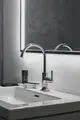 Waschtischarmatur mit zeitgemäßem Design und Hebelgriffen in Chrom. Ideal Standard. Anordnung vor einem Spiegel und einer hellen Wand.